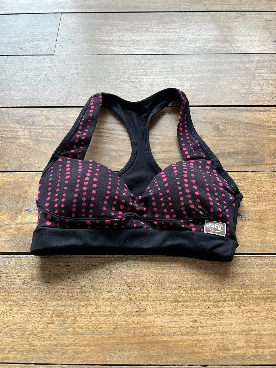 Top deportivo negro con lunares rosas. Ideal para todo tipo de actividades . Tiene reyeno. Marca City Sport.