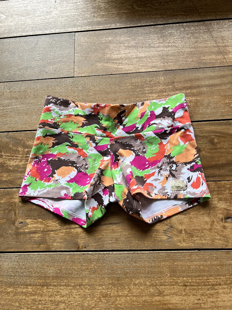 Short deportivo de mujer con estampado abstracto en tonos vibrantes. Ideal para actividades físicas o para un look casual y moderno. Confeccionado con tela suave y elástica para mayor comodidad y libertad de movimiento.