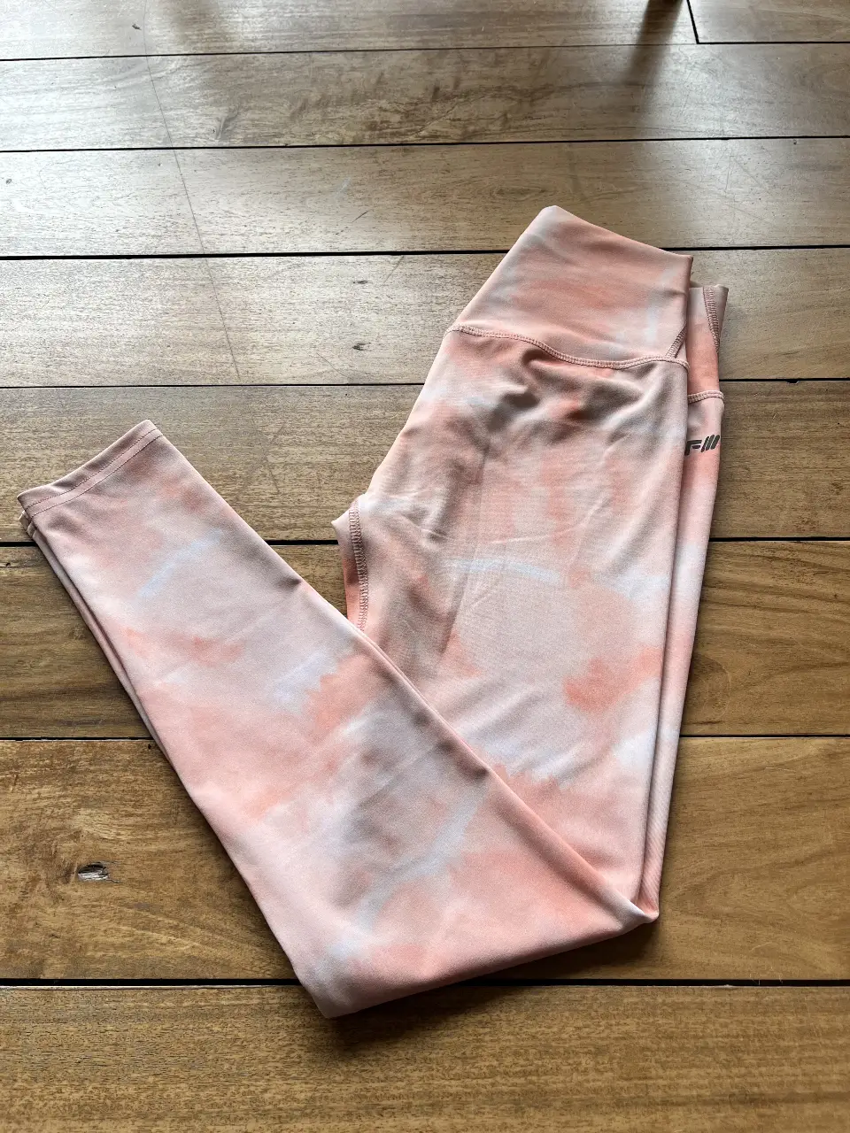 Calzas deportivas de mujer, con estampado tie dye en tonos durazno y blanco. Tiro alto, ideales para entrenamientos y actividades físicas. Marca Ladyfit.