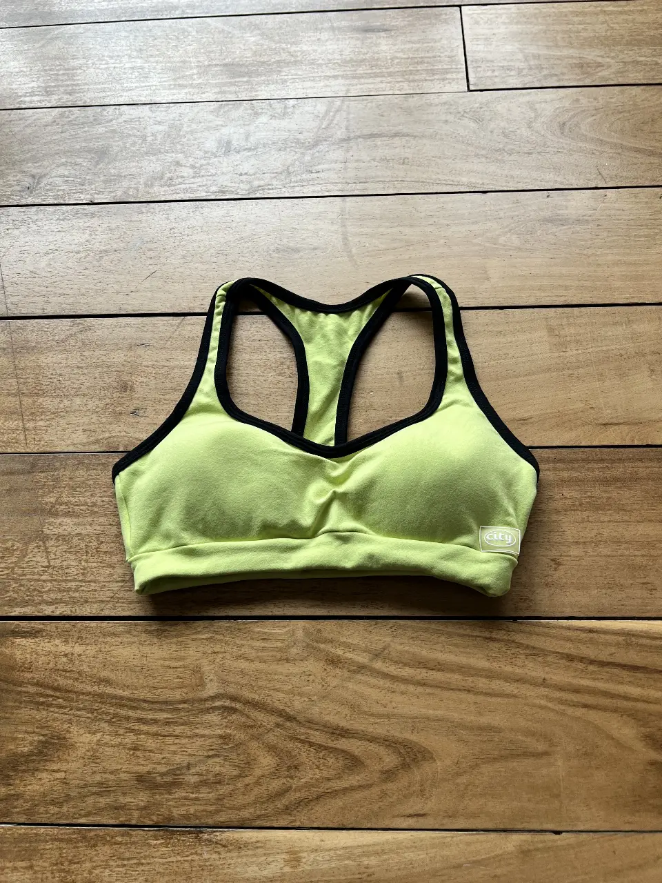 Top deportivo verde lima con detalles en negro. Ideal para entrenamientos y actividades físicas. Diseño cómodo y moderno. Tiene reyeno.