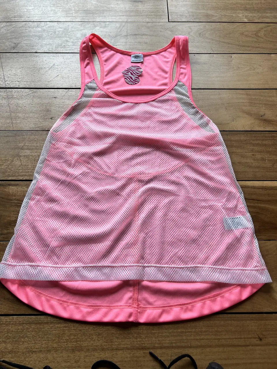 Musculosa deportiva rosa de mujer, con detalles en blanco y rosa. Ideal para entrenamientos y actividades físicas. Confeccionada con materiales transpirables y diseño cómodo.