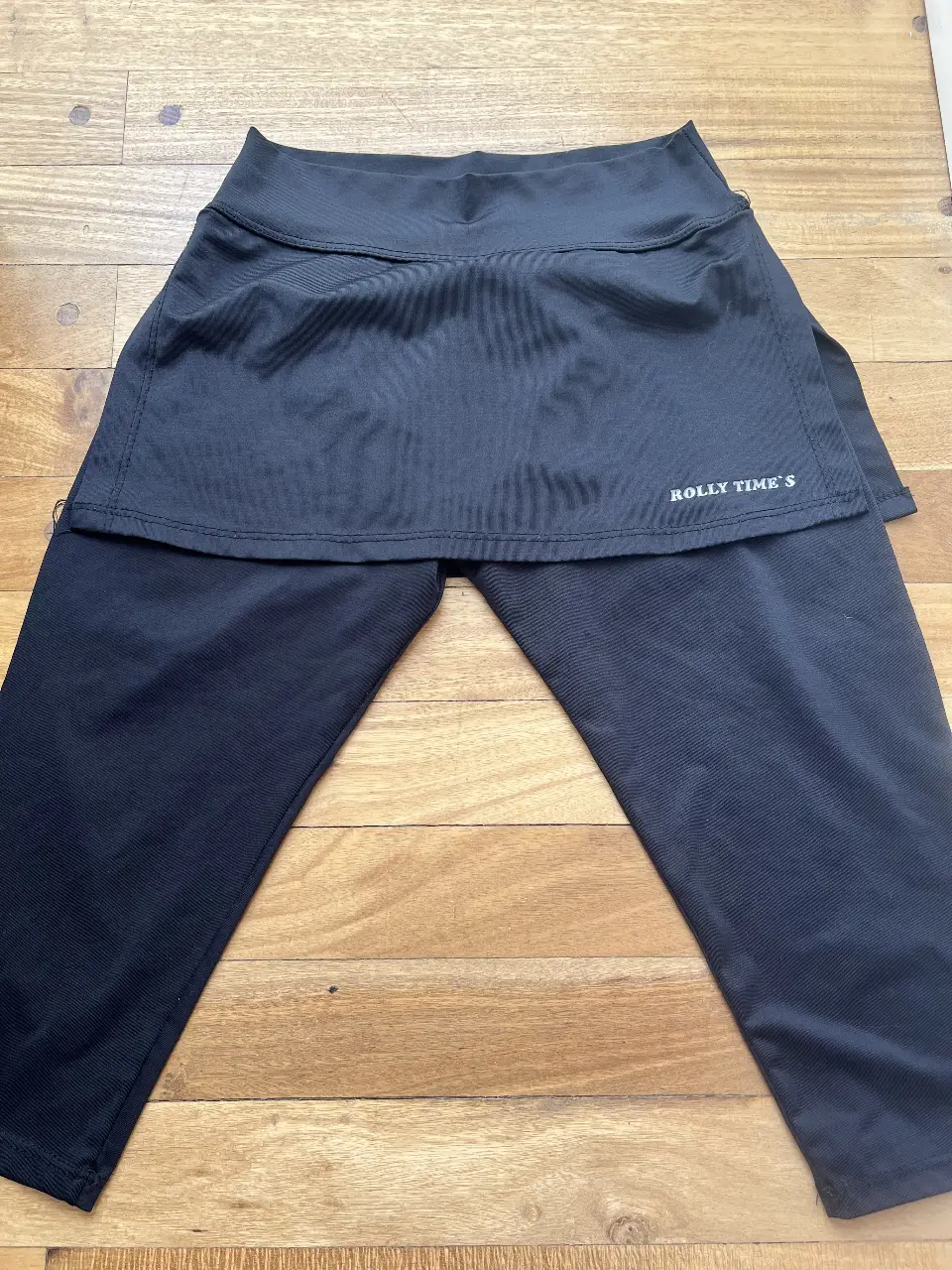 Pantalón deportivo negro con falda incorporada. Ideal para actividades físicas o un look casual y cómodo. Marca "Rolly Time's".