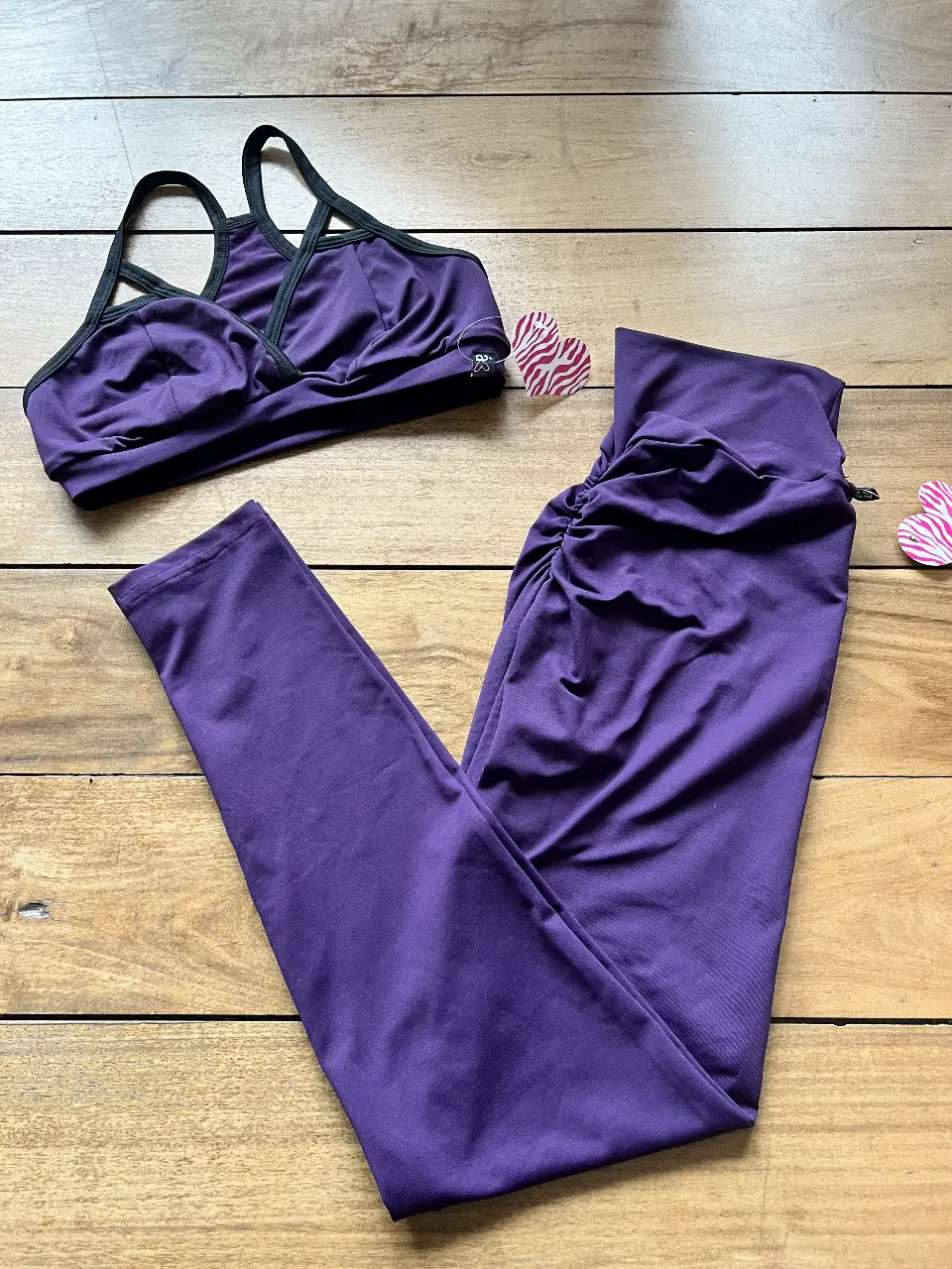 Conjunto deportivo de mujer en color violeta. Incluye un top con detalles en negro y calzas con fruncido. Ideal para entrenamientos. Es un Talle Unico pero similar a un M o talle 2 