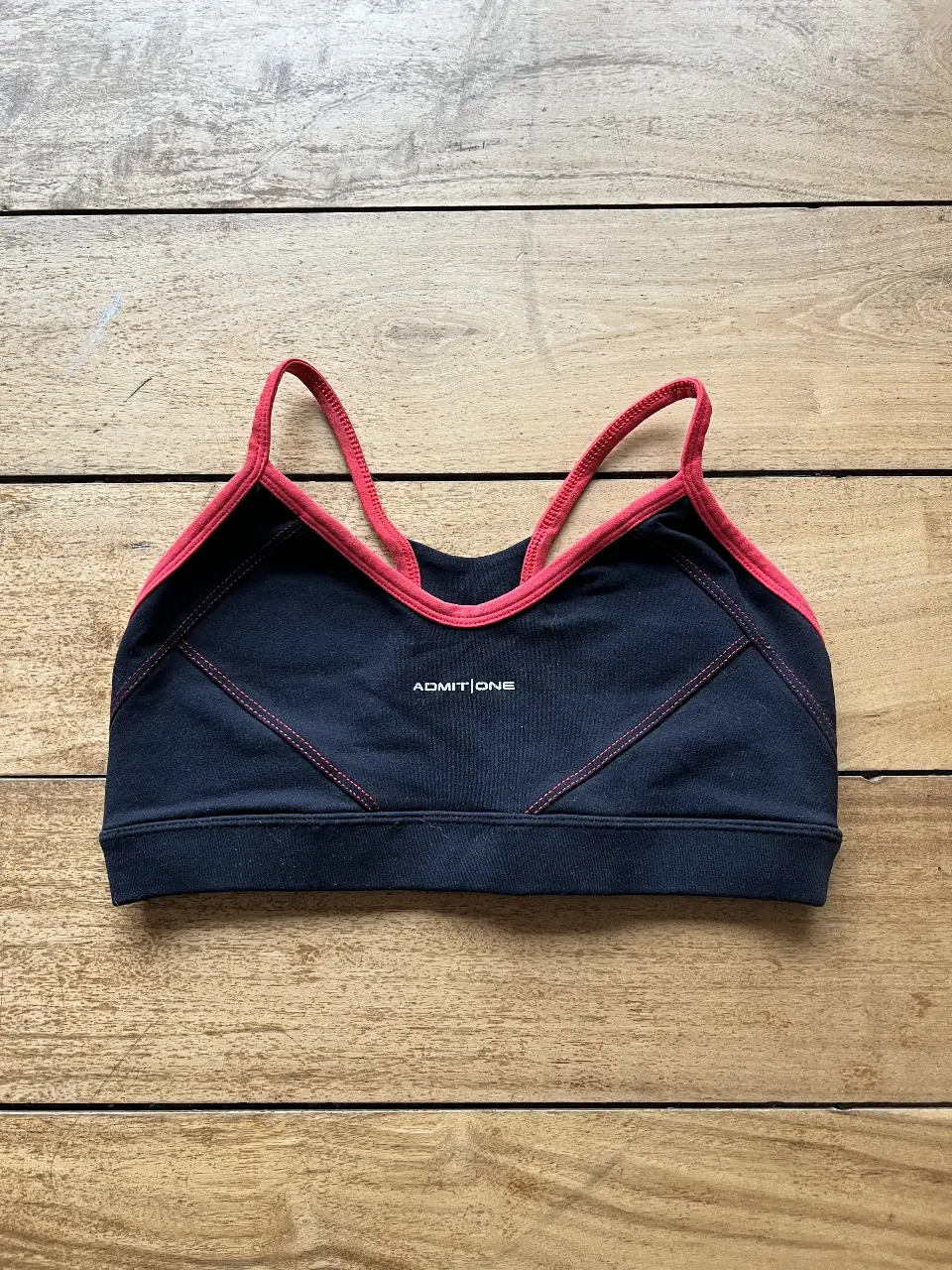 Top deportivo negro con detalles en rojo. Ideal para entrenamientos y actividades físicas. Diseño cómodo y ajuste perfecto. talle Unico. 