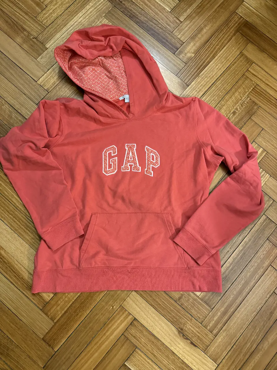 Buzo canguro GAP rojo con logo bordado en el frente. Talle L. Ideal para un look casual y cómodo.
