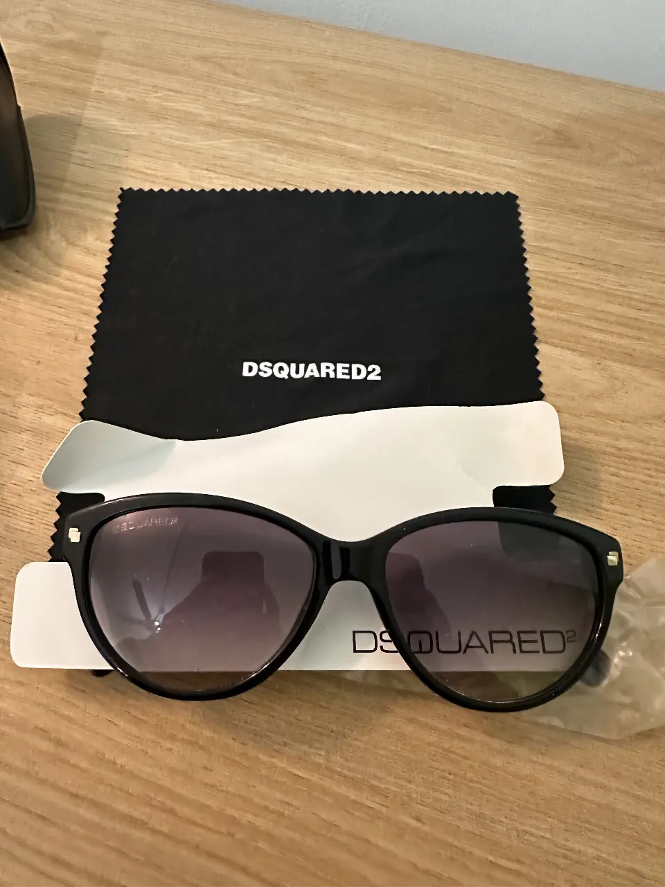 Anteojos de sol Dsquared2, con marco negro y cristales degradados. Incluye estuche, paño de limpieza y funda protectora.