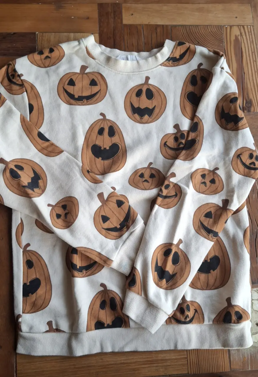 Buzo de cuello redondo para niño, con estampado de calabazas de Halloween. Ideal para un look casual y divertido.