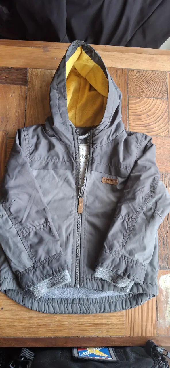 Campera para niño Carter's, gris con capucha y forro amarillo. Ideal para el invierno, con cierre y detalles en marrón.