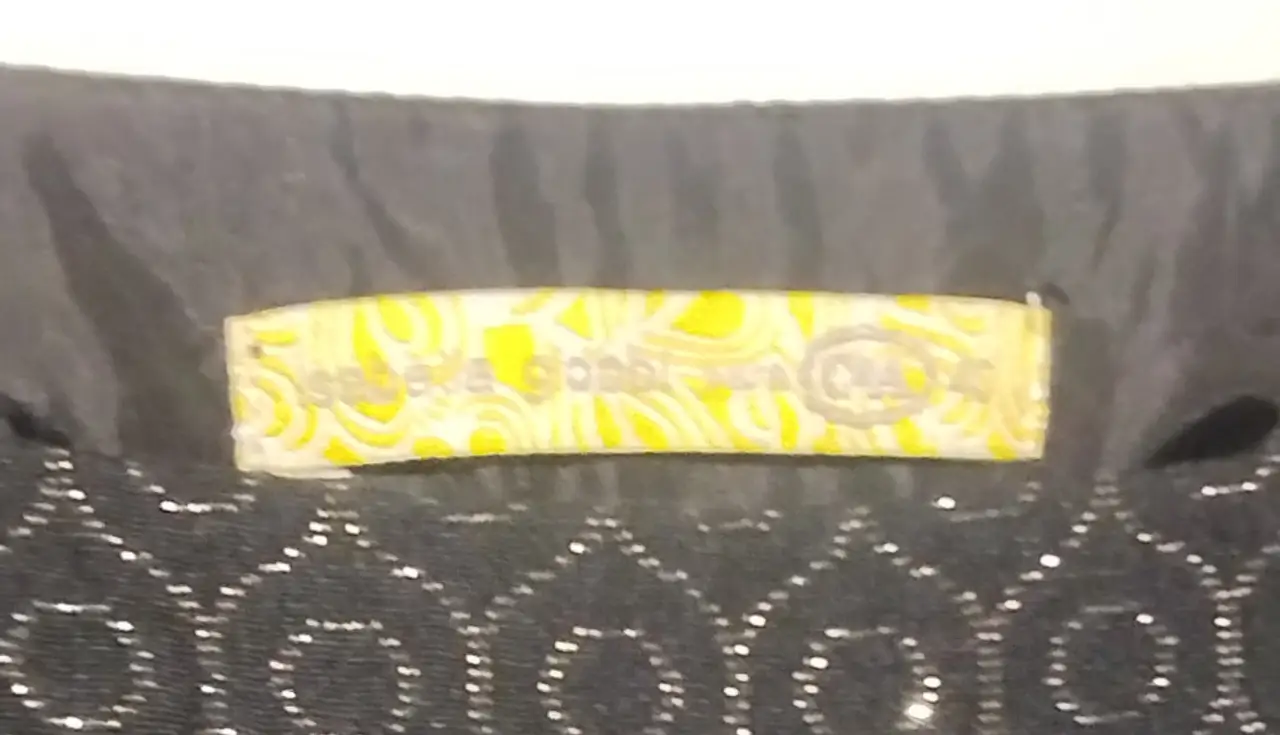 Pollera negra con diseño de círculos bordados en relieve con hilo dorado. Ideal para un look elegante y sofisticado.