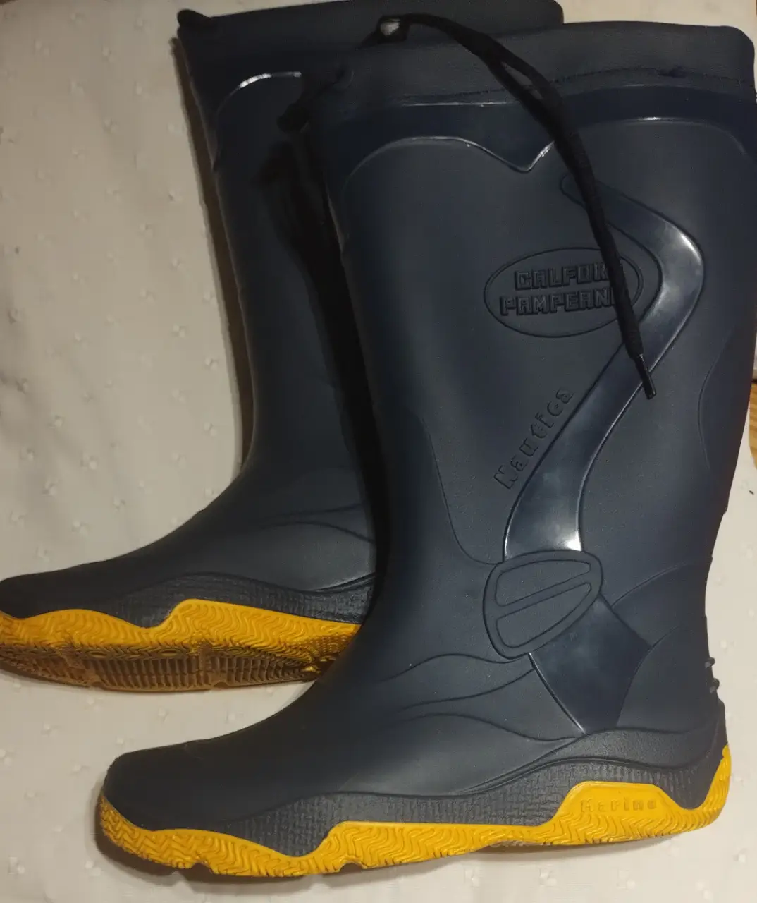 Botas de lluvia Nautica azules con suela amarilla. Ideales para días lluviosos y actividades al aire libre.
