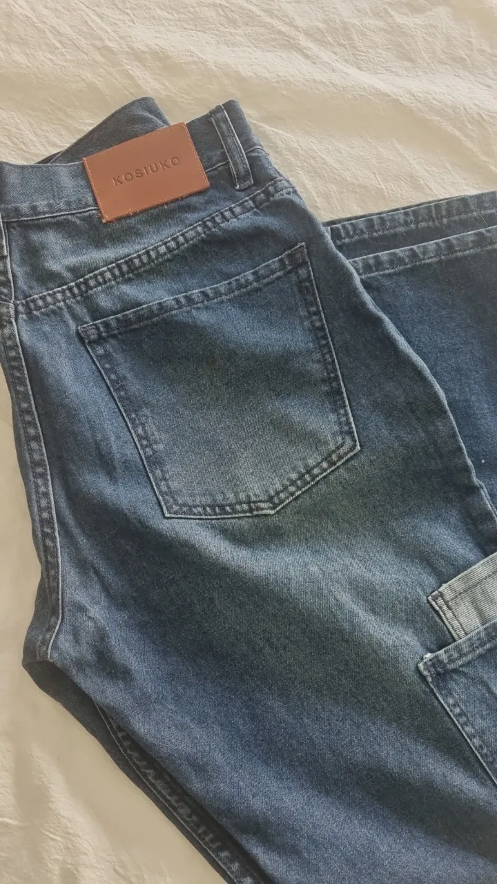 Jeans rectos de mujer, color azul, con etiqueta Kosiuko en la parte trasera. Bolsillos delanteros y traseros. Estilo cargo con bolsillos laterales.