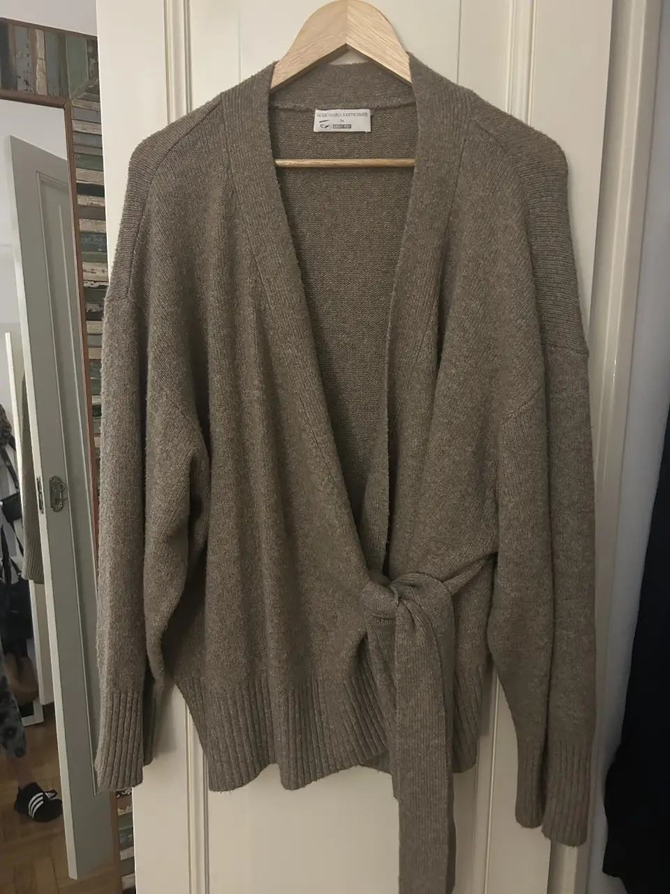 Cardigan de mujer color marrón con detalle de lazo en la cintura. Ideal para un look casual y cómodo.