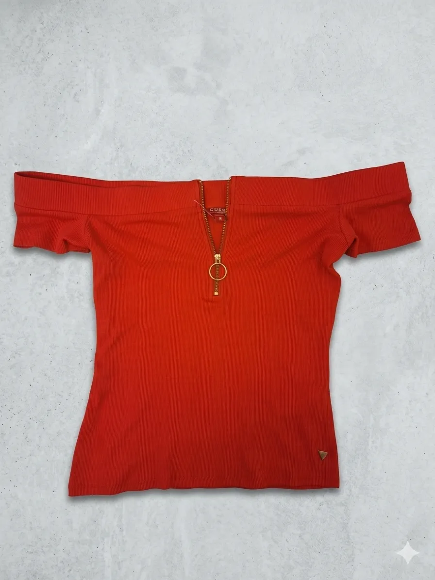 Remera escotada de hombros descubiertos  manga corta, color rojo vibrante, con cierre metálico dorado al frente y detalle de argolla. Perfecta para un look canchero y moderno.