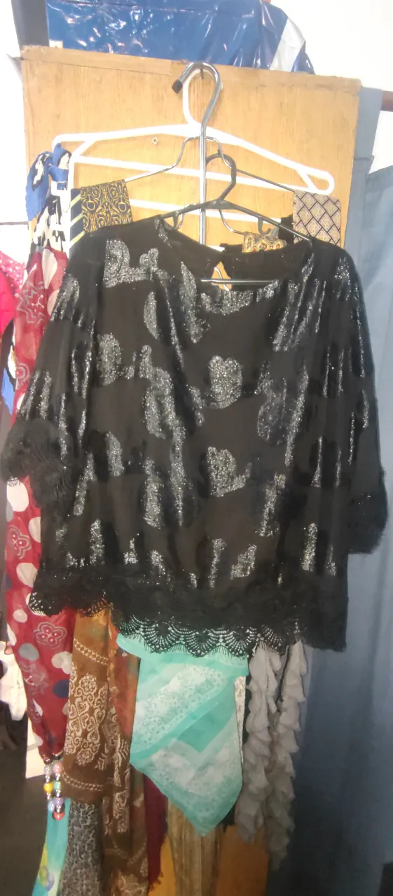 Blusa negra con detalles brillantes y encaje en el borde. Ideal para una fiesta o salida especial.