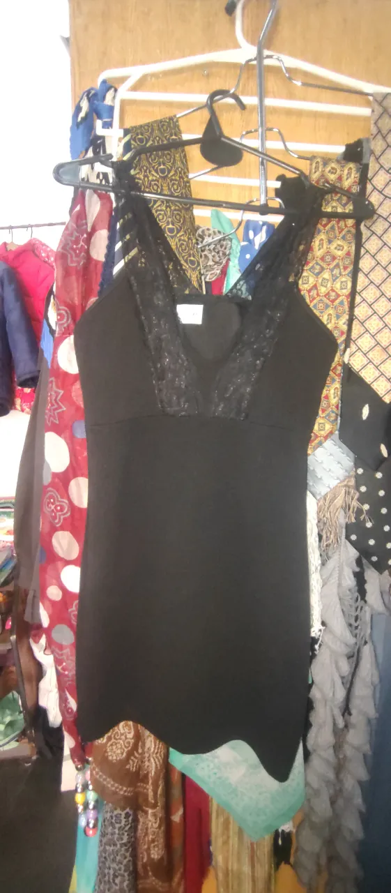 Vestido negro mini con detalles de encaje en el escote y tirantes. Ideal para una salida o fiesta.