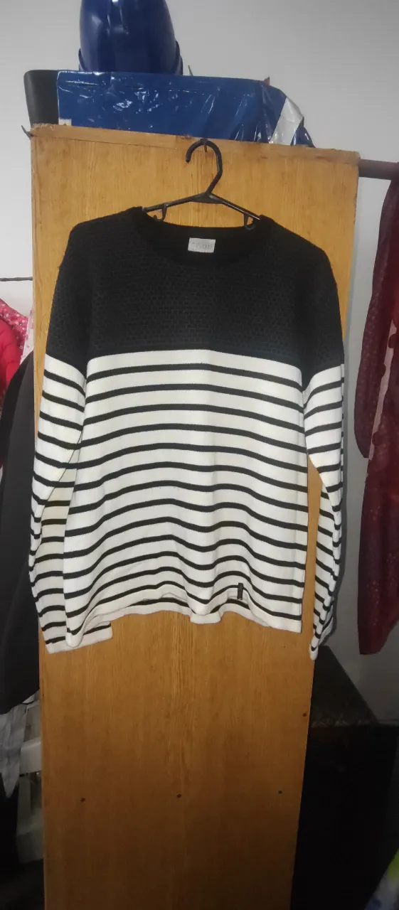 Sweater a rayas horizontales en blanco y negro, con cuello redondo. Ideal para un look casual y moderno.