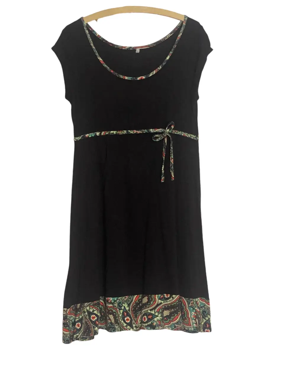 Vestido negro midi con detalles estampados en el cuello, cintura y borde inferior. Diseño con lazo en la cintura.