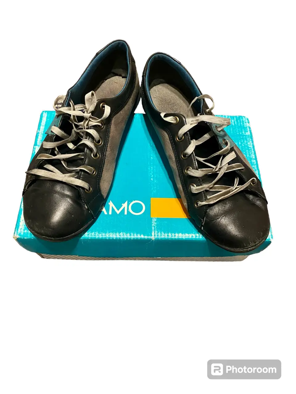 Zapatillas de cuero y gamuza negras y grises con cordones. Ideales para un look casual y cómodo.