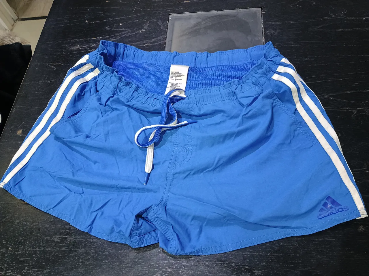 Short de baño Adidas azul con las tres tiras blancas a los costados. Ideal para la playa o pileta. Talle M.