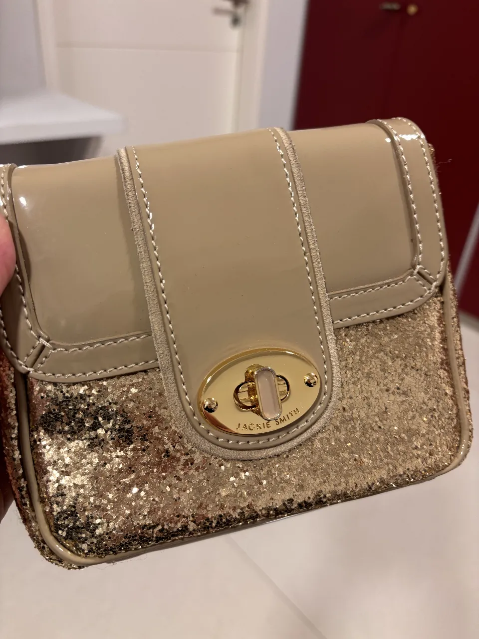 Cartera Jackie Smith dorada con solapa beige. Ideal para fiesta o salida.