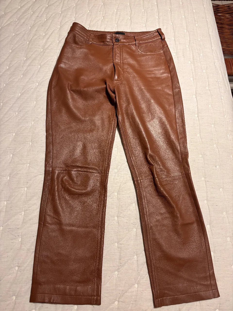 Pantalón de cuero marrón, tiro alto, con bolsillos delanteros y traseros. Talle 38. Ideal para un look elegante y moderno.