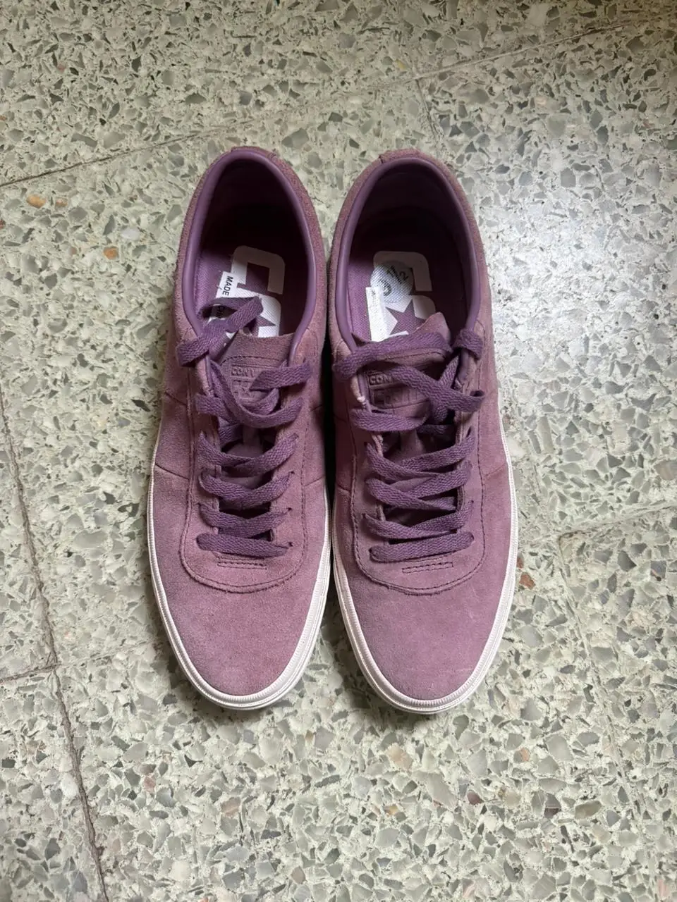 Zapatillas Converse de gamuza color violeta, con suela blanca y cordones a tono. Ideales para un look casual y cómodo.