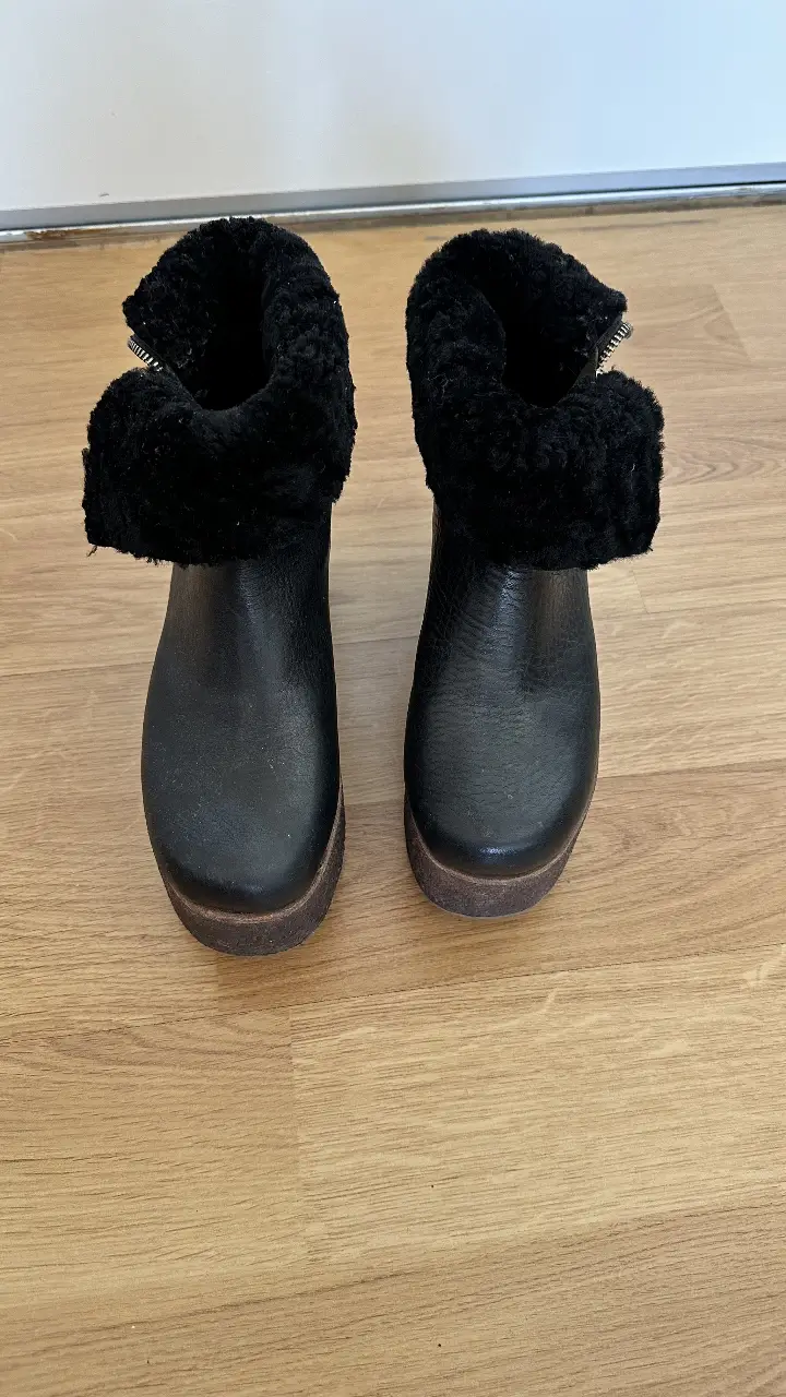 Botines negros de cuero con plataforma y detalle de piel en el borde superior. Diseño moderno y abrigado, ideales para el invierno. Marca Paruolo.