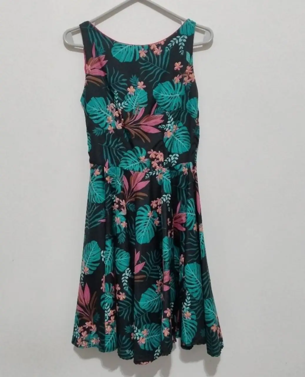 Vestido mini con estampado floral tropical en tonos verdes, rosas y detalles en negro. Ideal para un look fresco y veraniego. Perfecto para salidas casuales o eventos informales.