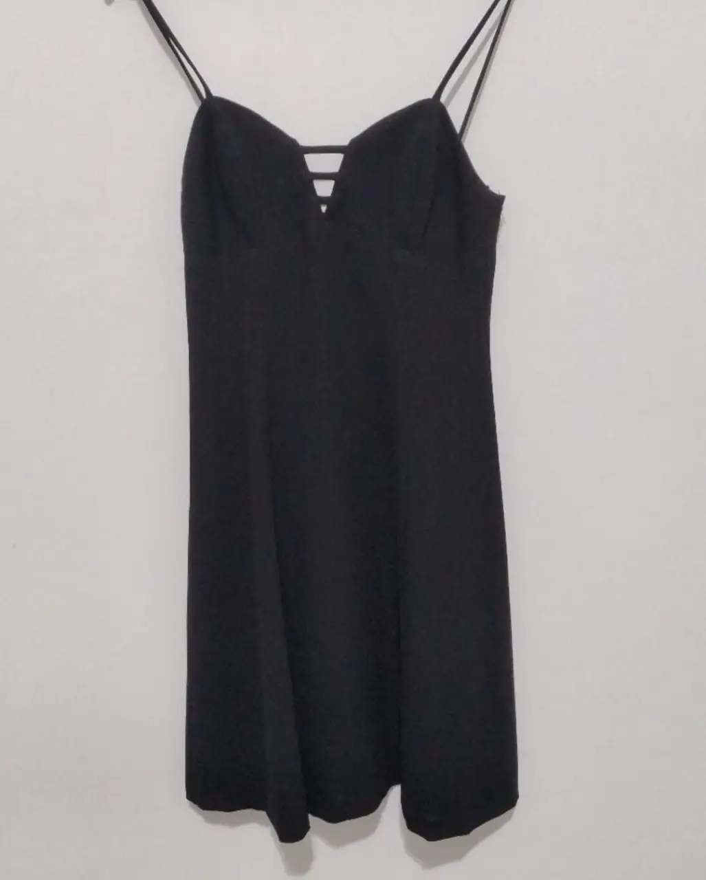 Vestido negro corto con tiras finas y escote en V. Ideal para una salida o fiesta.