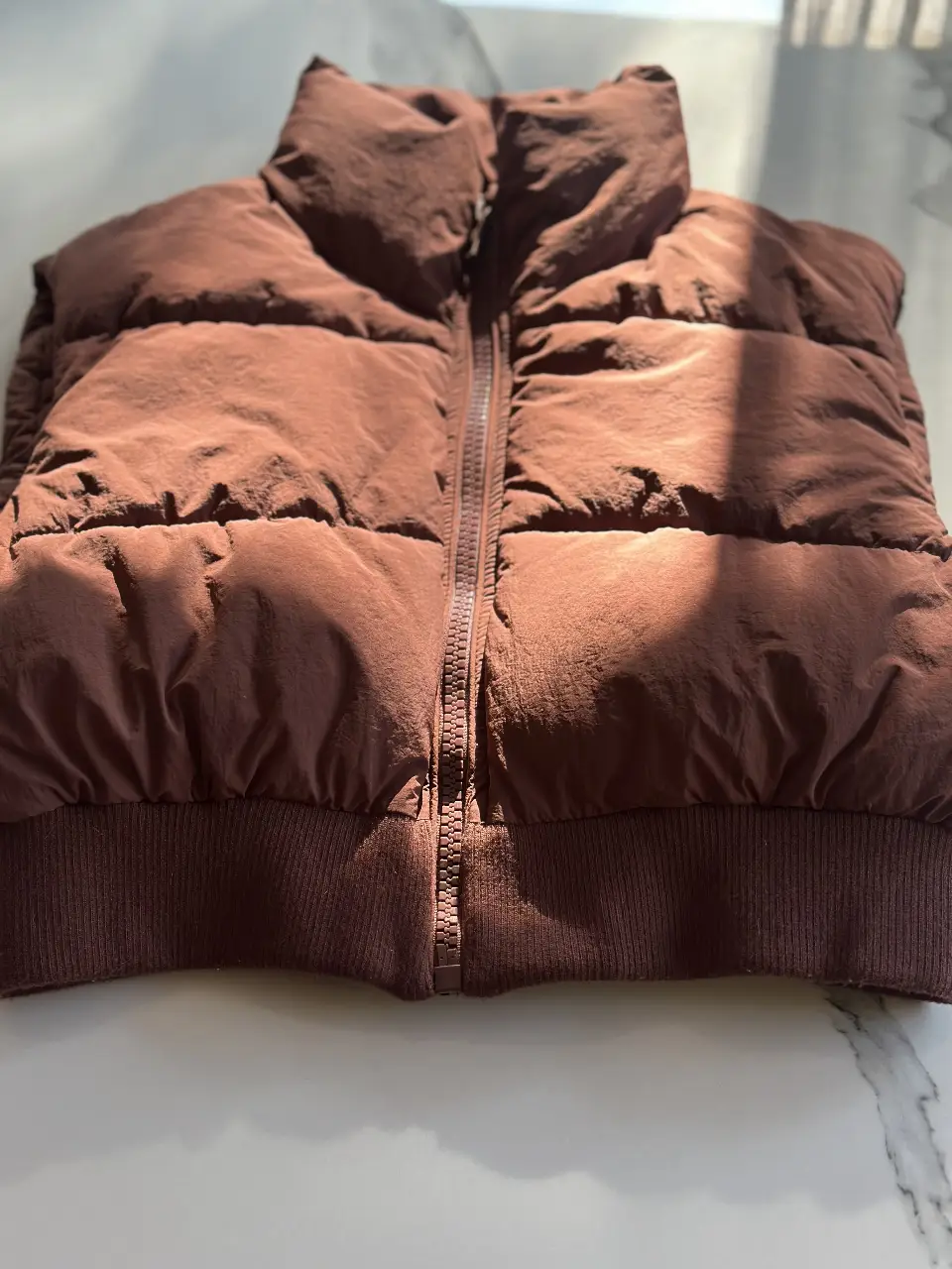 Chaleco puffer marrón de la marca Zara, ideal para el invierno. Confeccionado con materiales de calidad, este chaleco ofrece abrigo y estilo. Perfecto para un look casual y moderno.