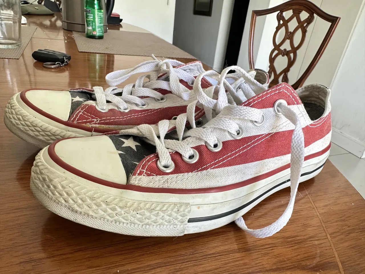 Zapatillas Converse con diseño de la bandera de Estados Unidos. Cordones blancos y suela de goma.