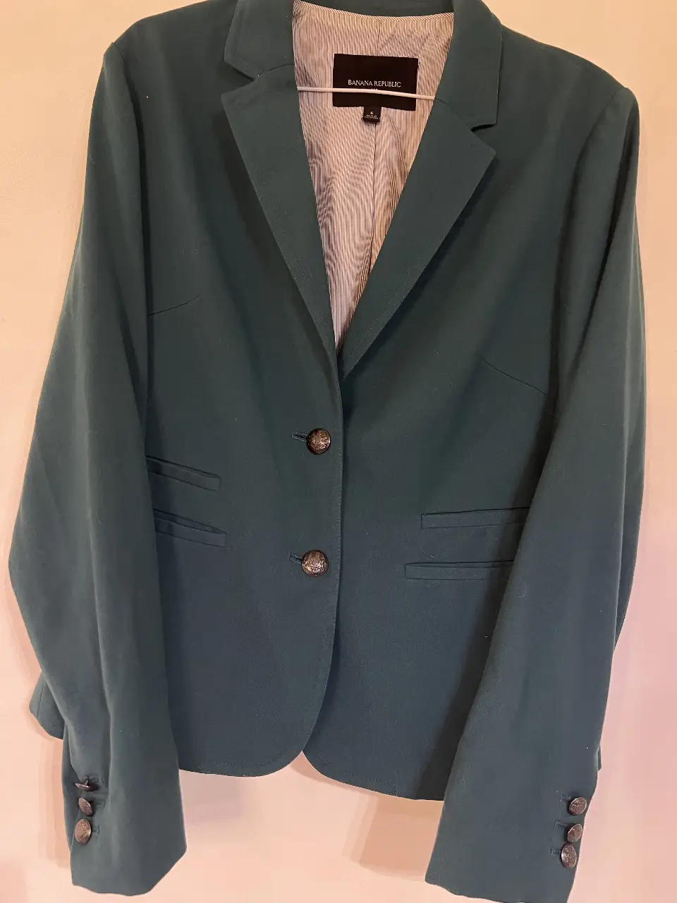 Blazer de mujer Banana Republic, color verde oscuro, con dos botones y bolsillos delanteros. Ideal para un look formal o de trabajo.