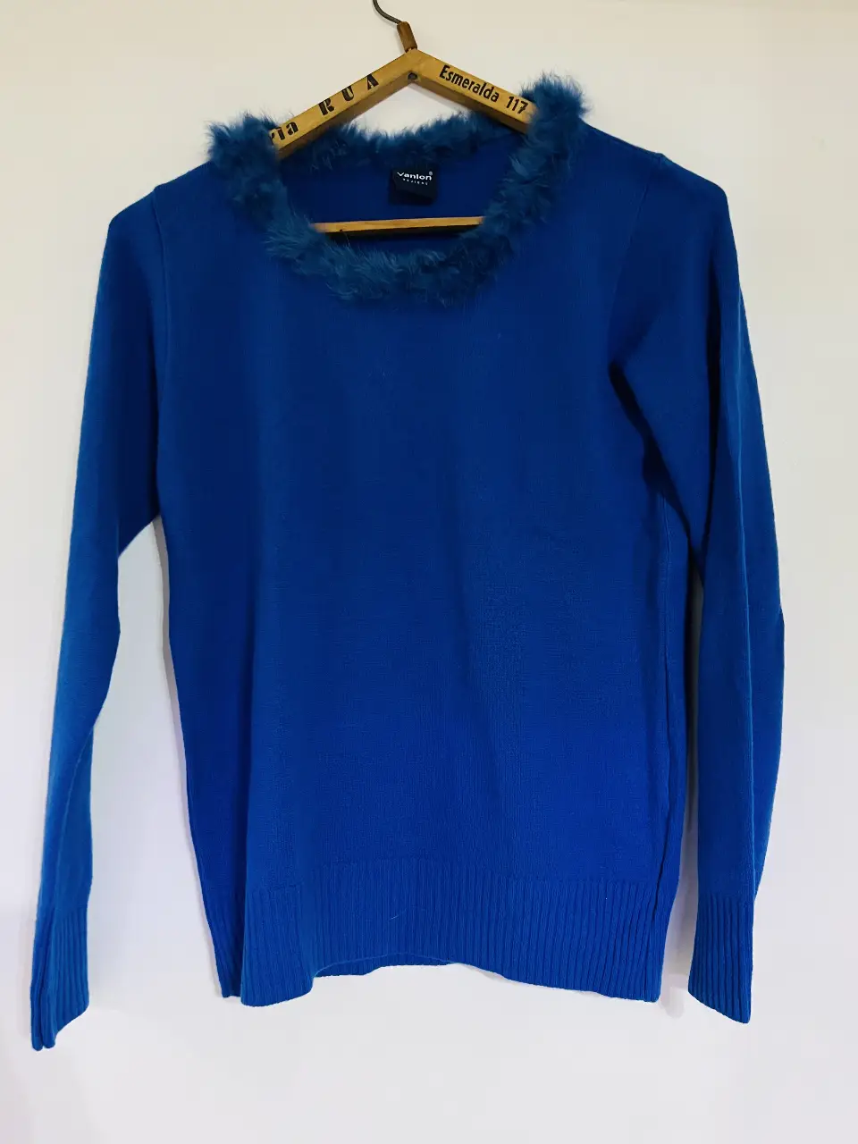 Sweater azul con cuello en V y detalle de piel en el cuello. Ideal para un look elegante y abrigado.