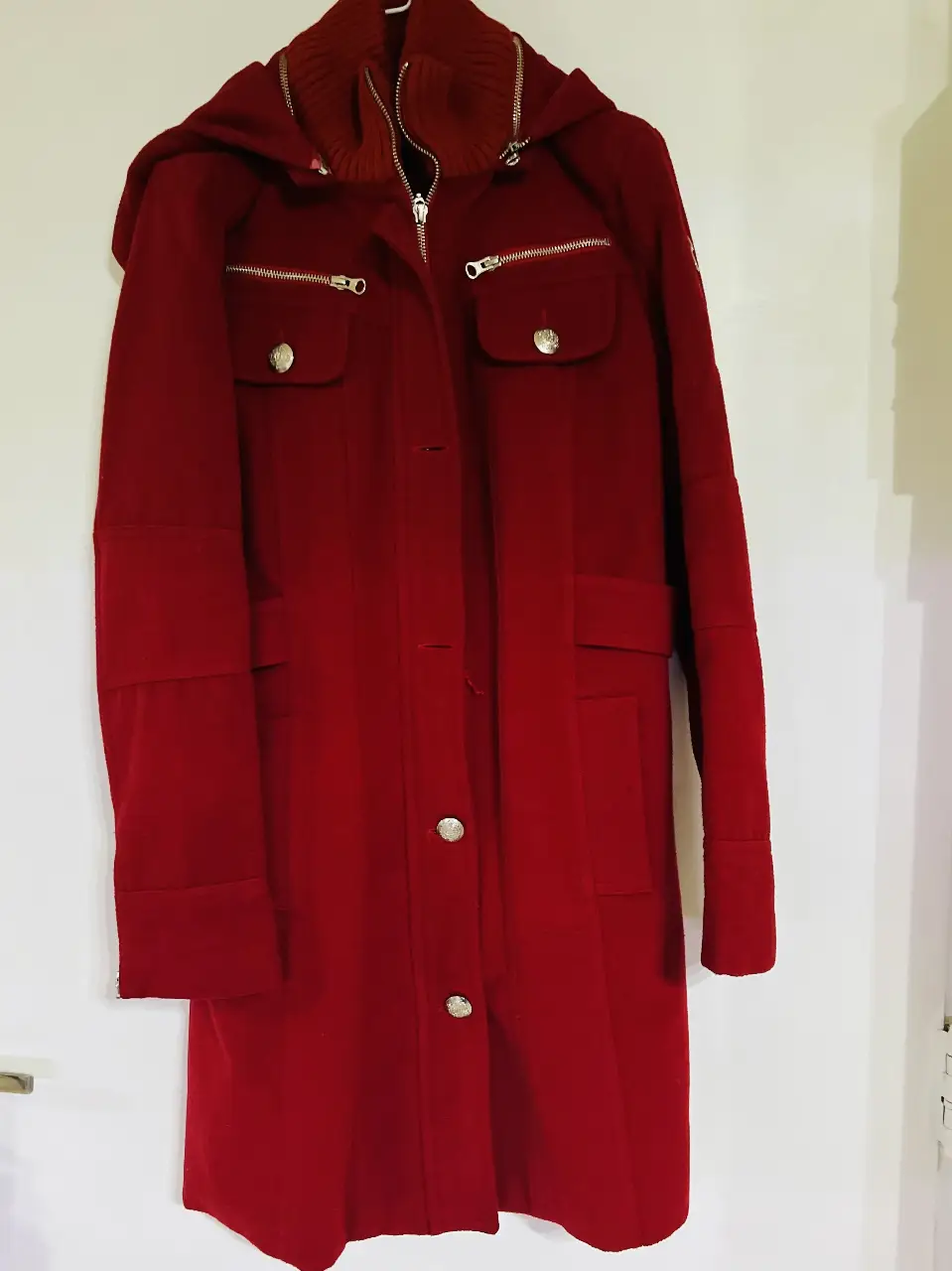 Tapado largo de paño rojo con capucha desmontable y detalles dorados. Ideal para el invierno, con un estilo elegante y abrigado.