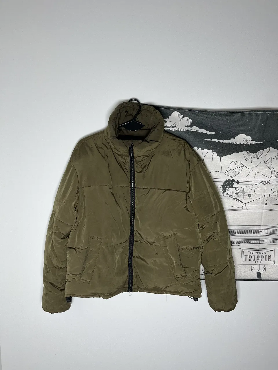 Campera puffer verde militar, ideal para el invierno. Con cierre frontal y cuello alto. Perfecta para un look casual y abrigado.