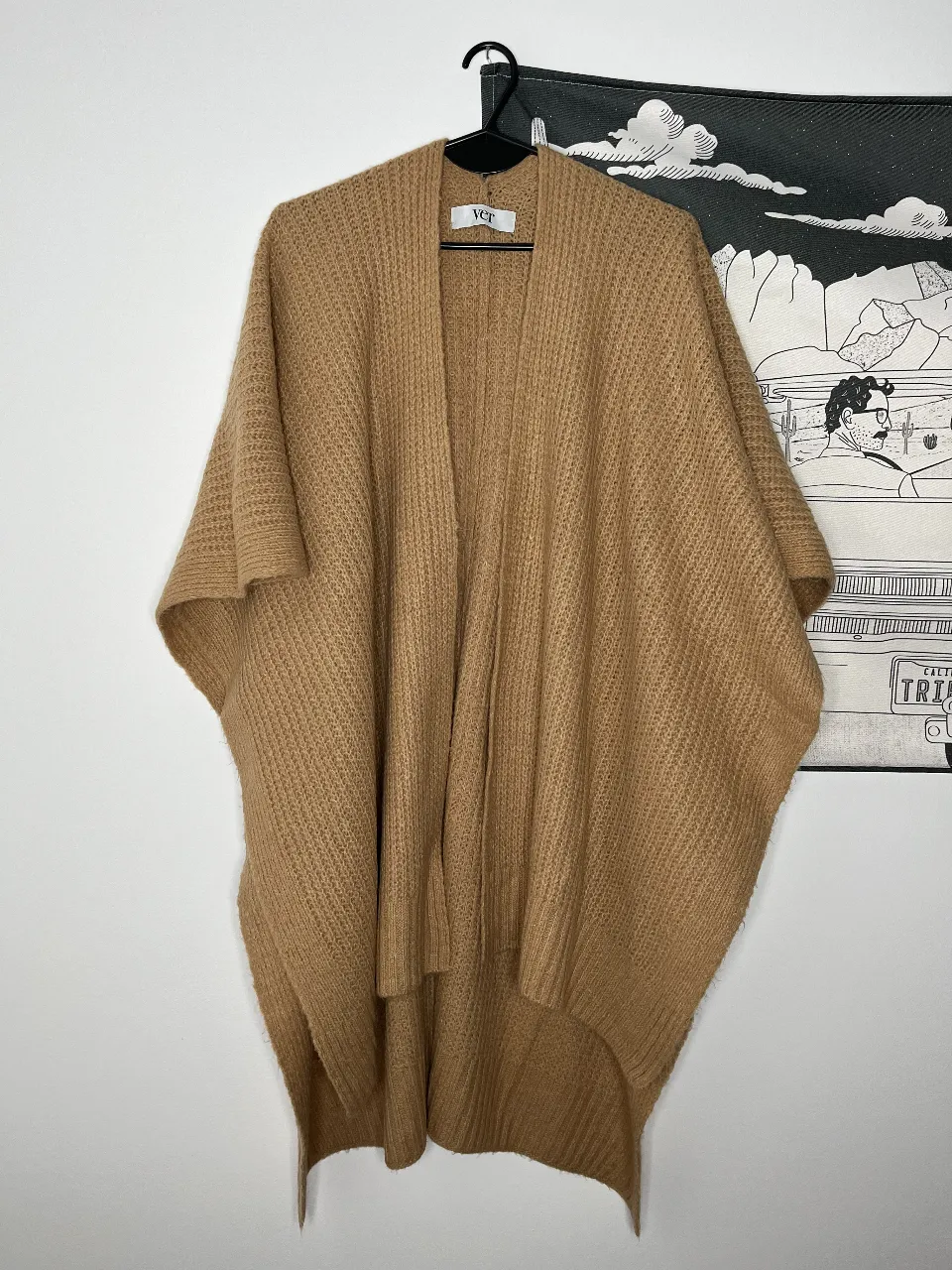 Cardigan de tejido grueso en color marrón camel, con diseño de poncho. Ideal para un look casual y abrigado.