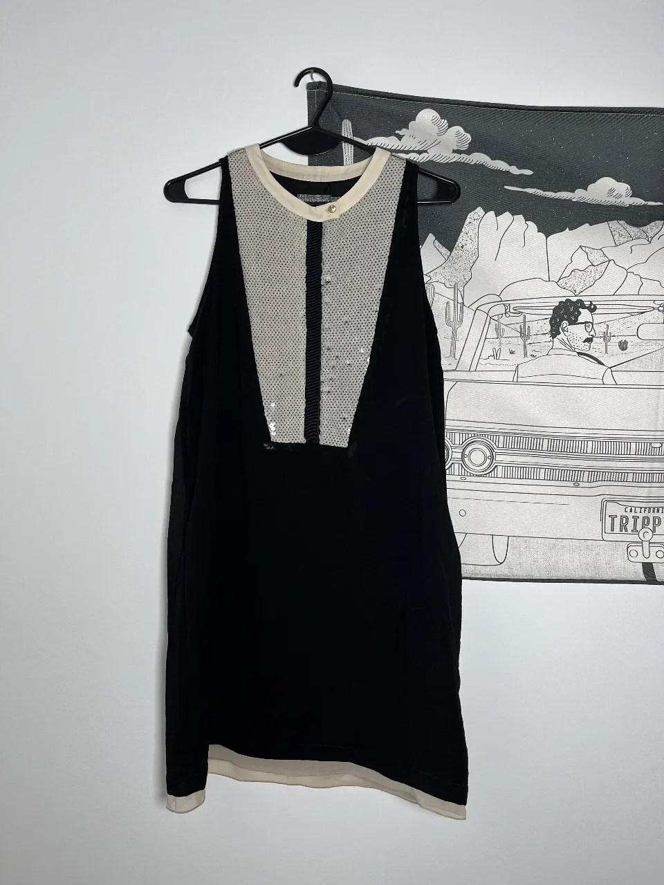Vestido mini negro con detalles en blanco y lentejuelas. Ideal para una fiesta o salida especial. Diseño elegante y moderno.