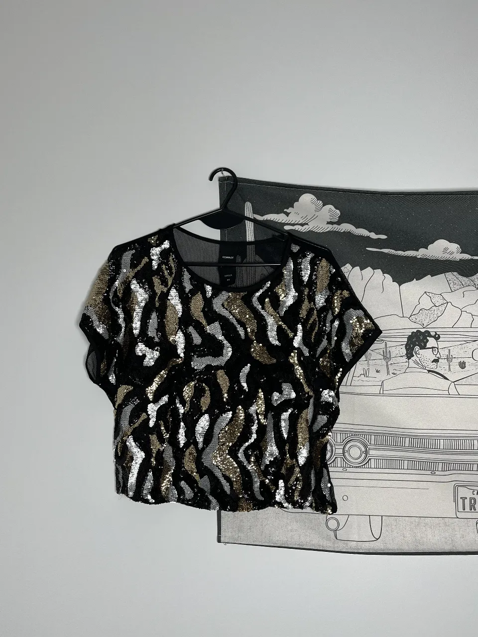 Top de mujer con lentejuelas en tonos dorados y plateados sobre base negra. Espalda con transparencia. Ideal para fiestas y eventos especiales. Diseño moderno y llamativo.