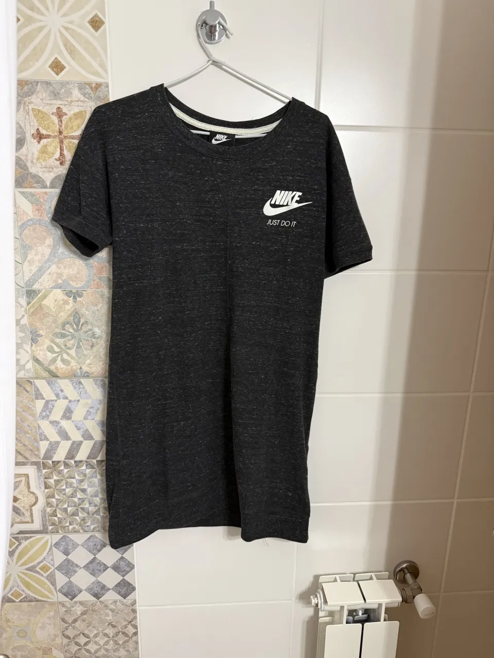 Remera manga corta de color gris oscuro con logo de Nike blanco y la frase "JUST DO IT" estampada en el frente.