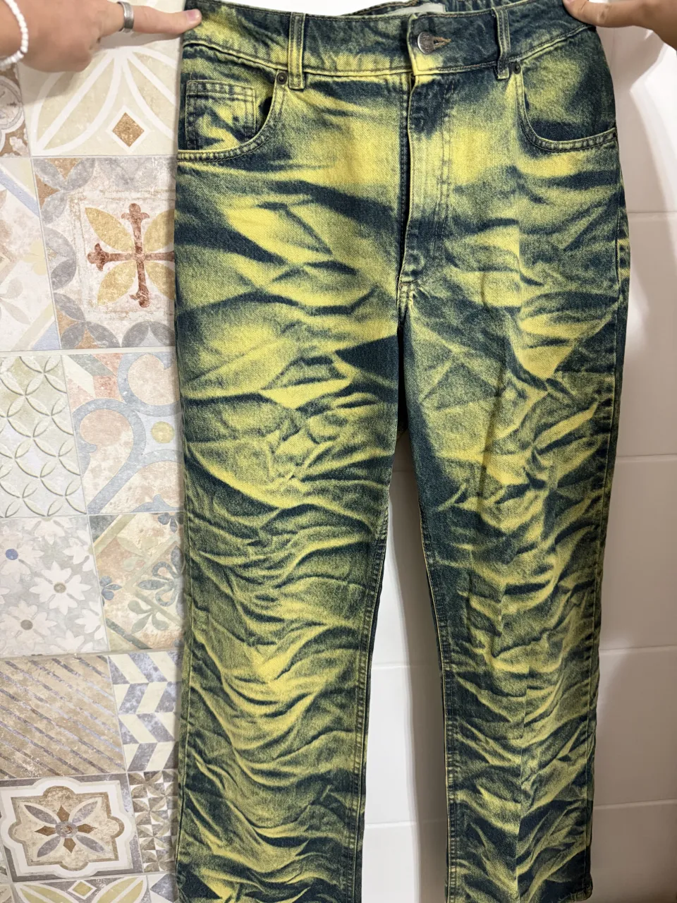 Jeans con lavado tie-dye en tonos de azul y amarillo. Presentan bolsillos delanteros y traseros.