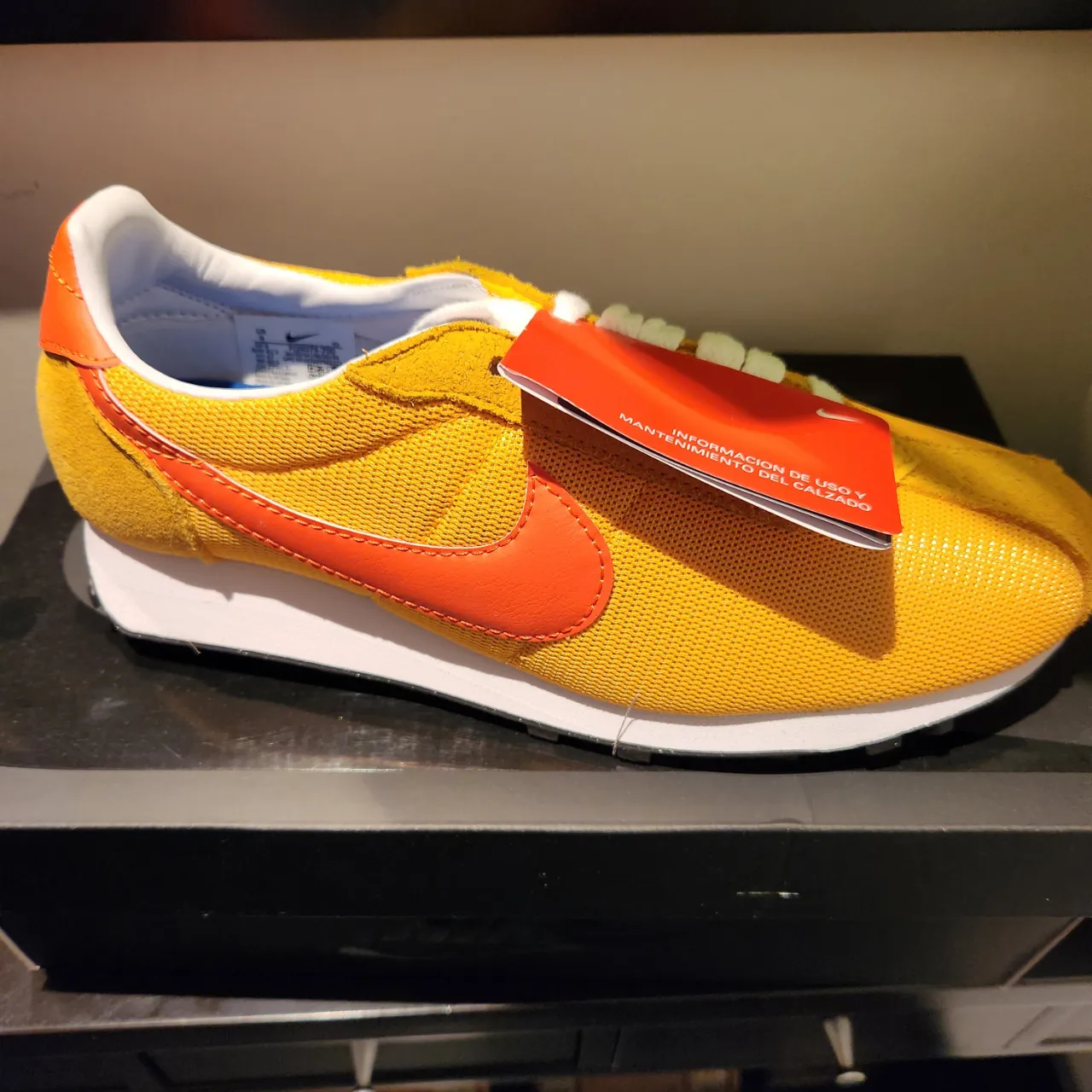 Zapatillas Nike amarillas con detalles en naranja, ideales para un look casual y deportivo. Con el logo de la marca bien visible, estas zapatillas combinan estilo y comodidad.