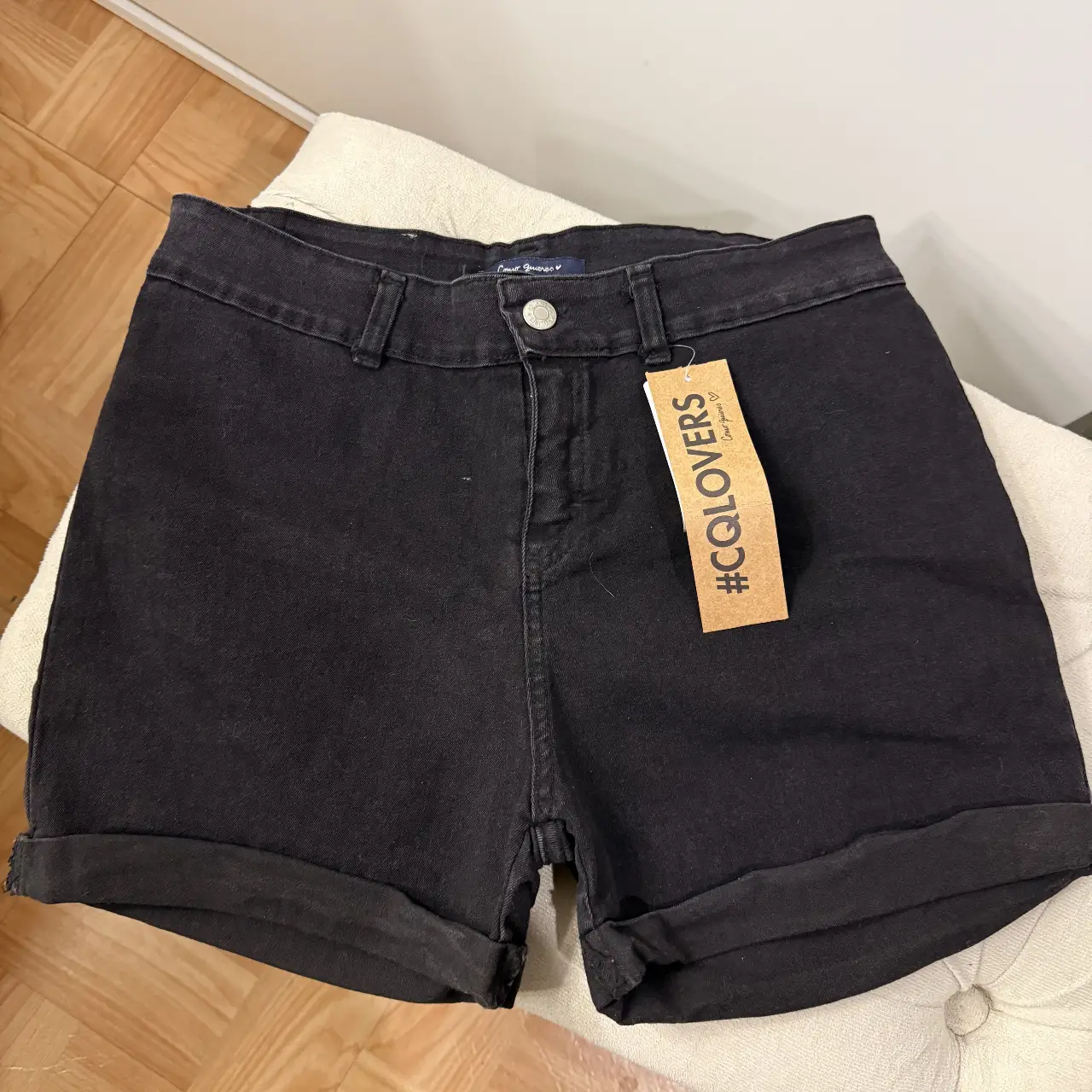 Short de jean elastizado negro de tiro medio con etiqueta de la marca Como Quieres. Ideal para un look casual y cómodo. TALLE 46.