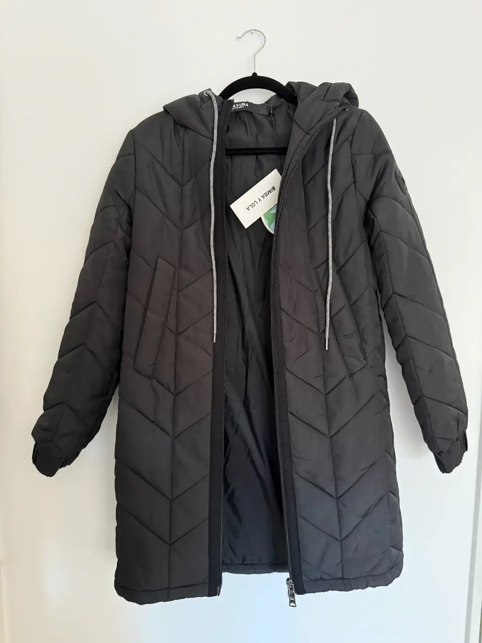 Campera larga acolchada para mujer, color negro, con capucha y cierre. Ideal para el invierno.
