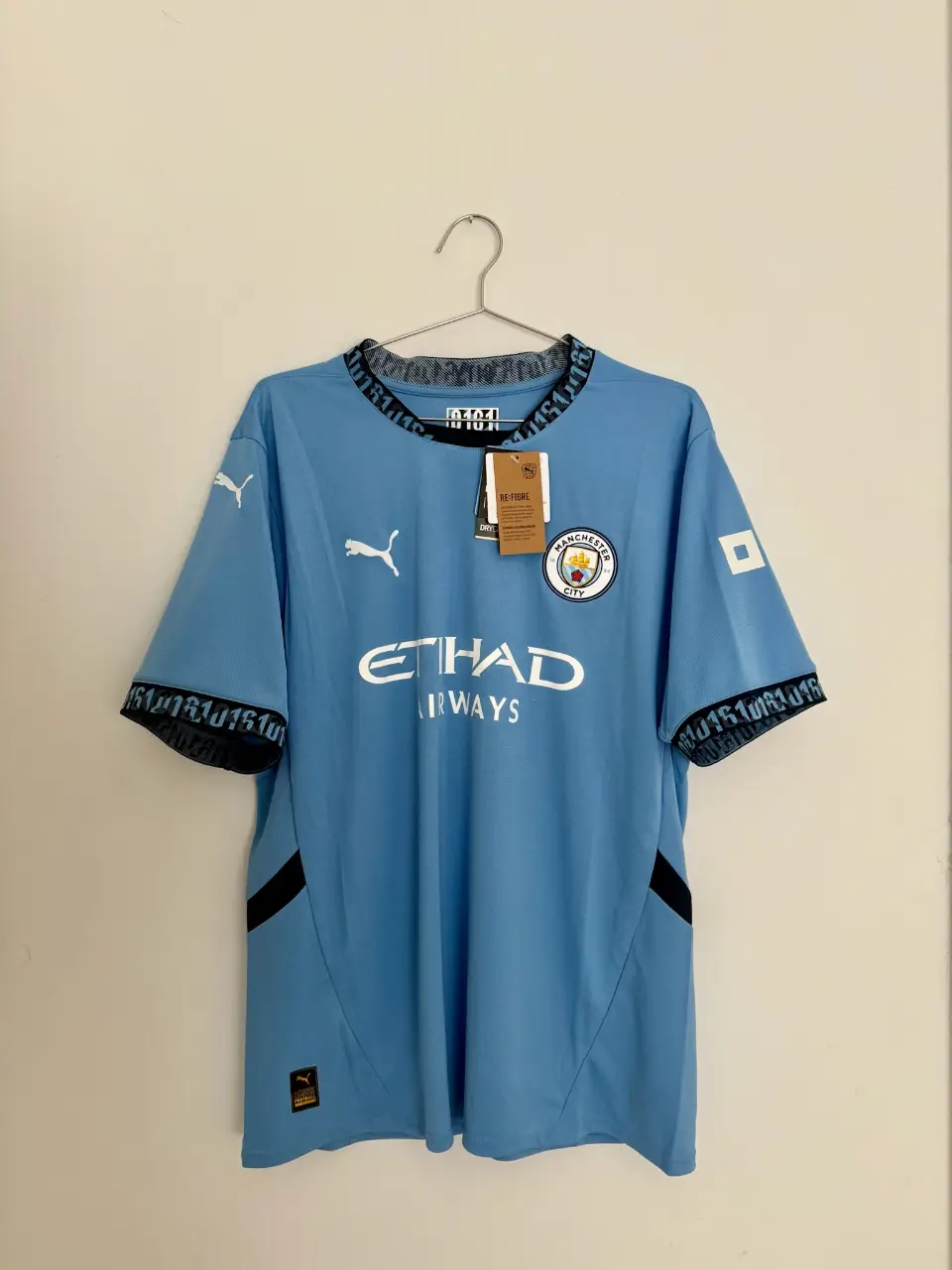 Camiseta de fútbol del Manchester City, temporada 2022/2023. Color celeste con detalles en negro y blanco. Con el nombre y número de Haaland en la espalda. Ideal para fanáticos y coleccionistas.