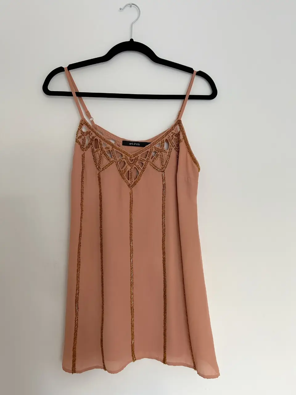 Vestido mini de tirantes con detalles dorados en el escote y en la parte delantera. Ideal para una salida o fiesta.