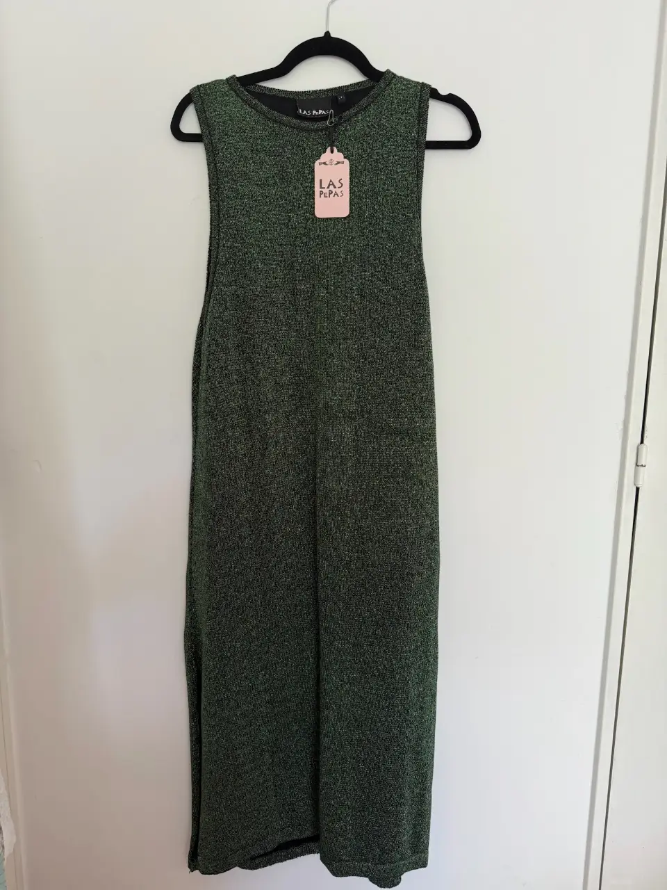 Vestido midi de punto en color verde con detalle de etiqueta de la marca. Ideal para un look casual y cómodo.