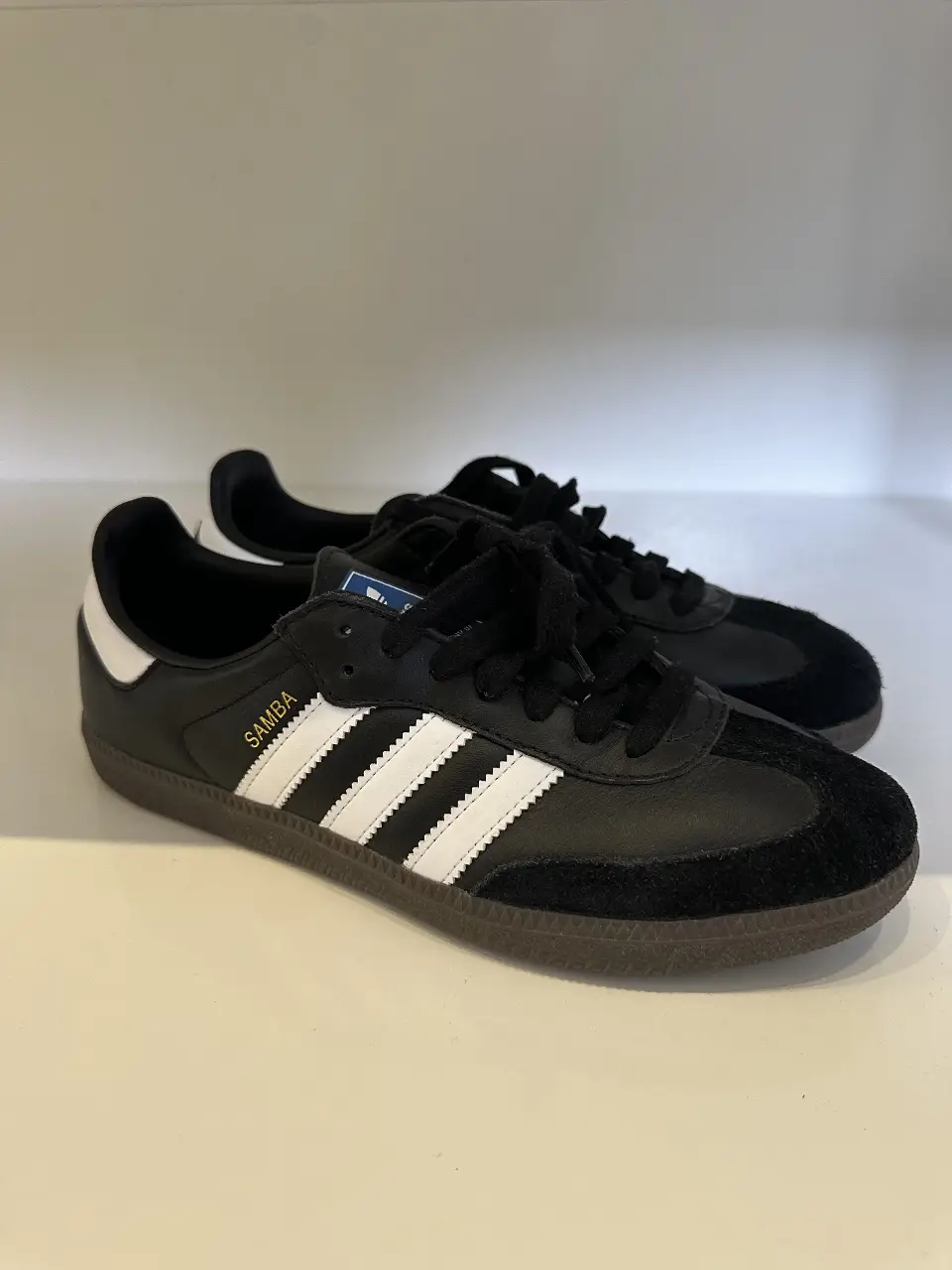 Zapatillas Adidas Samba negras con detalles blancos. Un clásico del calzado deportivo, ideales para un look casual y urbano.