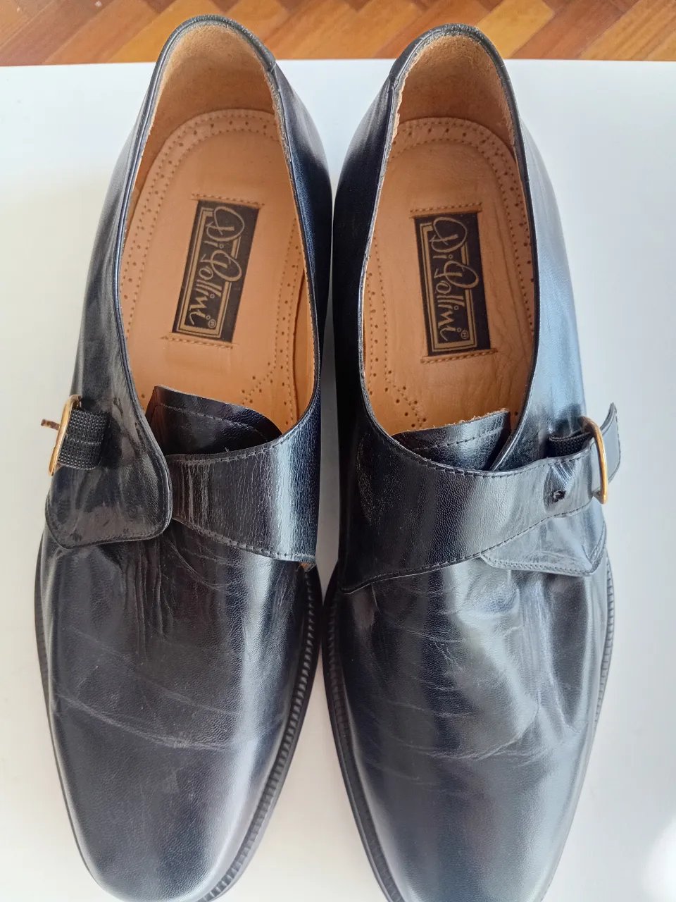 Zapatos negros de cuero con hebilla dorada y detalle de costura en la puntera. Marca Di Pollini grabada en la plantilla y en la suela.