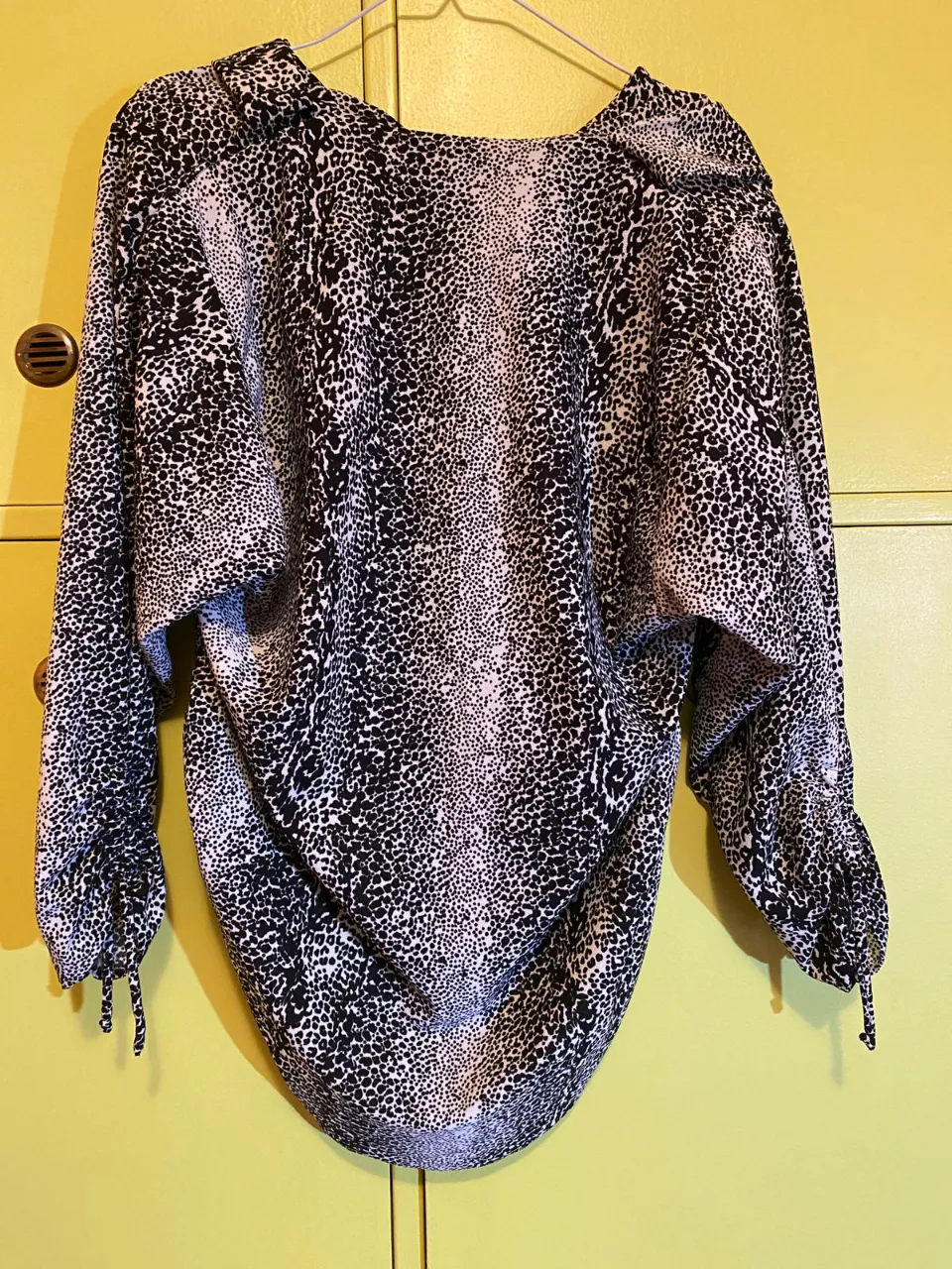 Blusa de mujer con estampado animal print en blanco y negro. Diseño holgado con mangas largas y puños ajustados. Ideal para un look moderno y sofisticado. Manga 7/8. Talle: 44-46. Medidas: ancho de pecho de la prenda: 48cm, largo de la prenda: 76-77cm, ancho del hombro de la prenda: 44cm