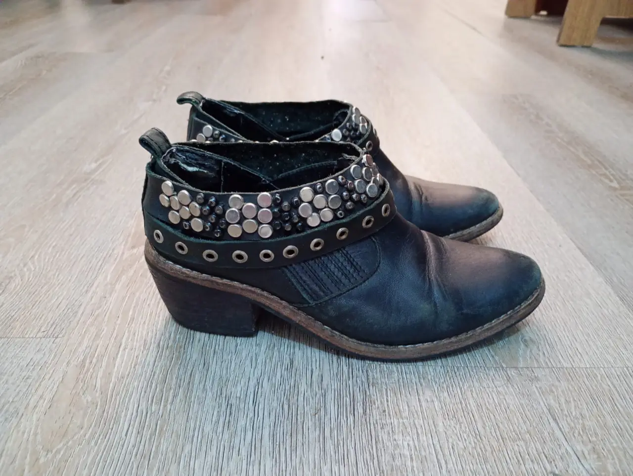 Botas negras de cuero con detalles de tachas plateadas y hebillas. Estilo rocker, ideales para un look audaz y con onda.